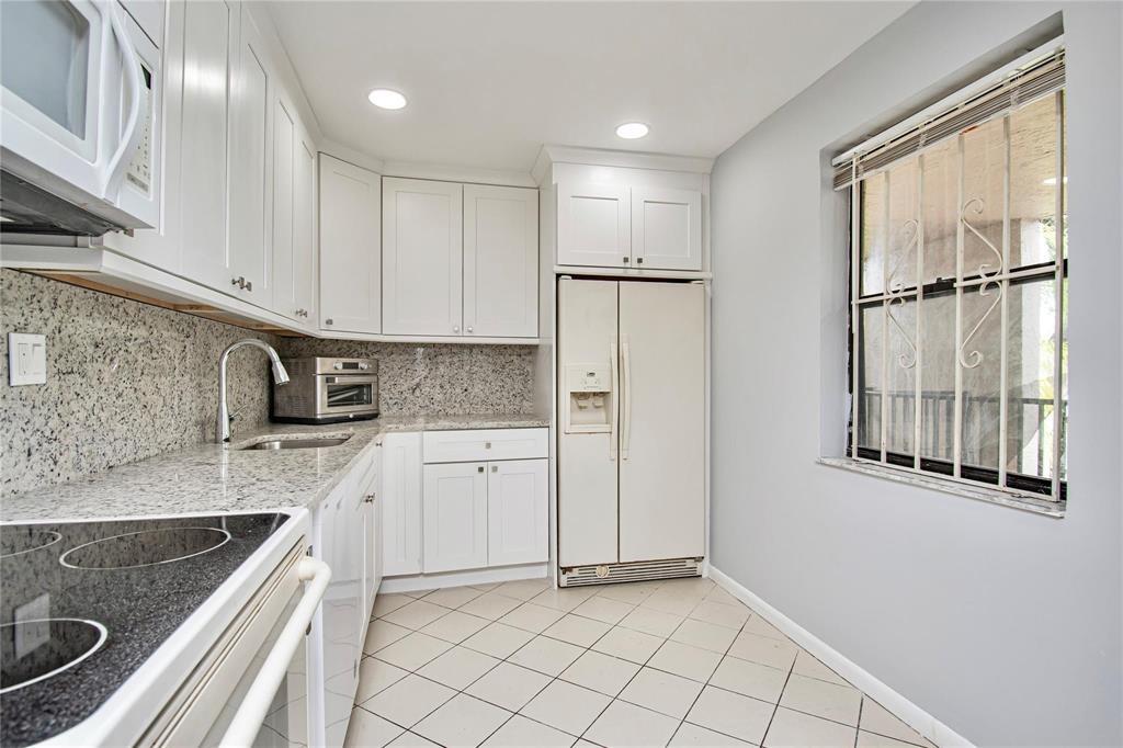 8150 West McNab Road, Unit 312 Tamarac, FL 33321 - Photo 6 of 32 a kitchen with granite countertop a sink stove and refrigerator