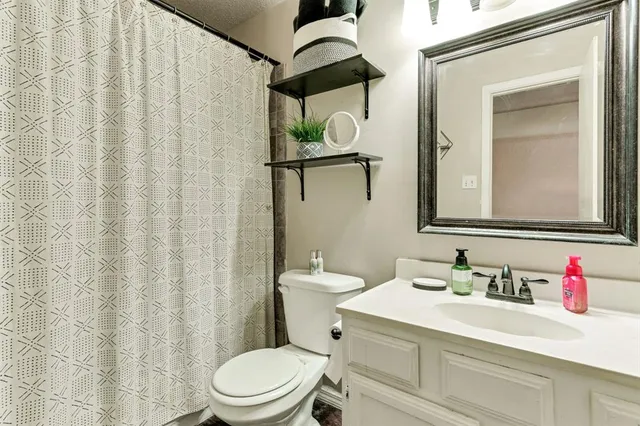 a bathroom with a sink vanity mirror and toilet