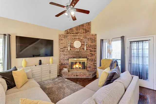 a living room with furniture a flat screen tv and a fireplace