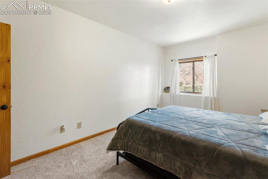 9110 Mountain Road Cascade, CO 80809 - Photo 32 of 49 a bed sitting in a bedroom next to a window