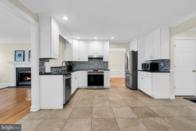 a kitchen with granite countertop a stove top oven and cabinets