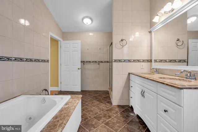 a bathroom with a tub sink and mirror