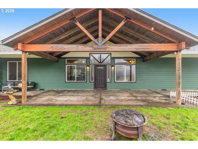 a backyard of a house with barbeque oven table and chairs