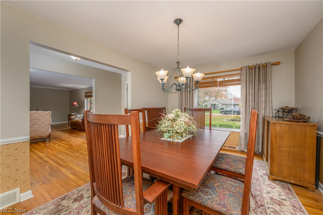2969 Chamberlain Road Akron, OH 44333 - Photo 13 of 33 Dining space featuring a notable chandelier and light hardwood / wood-floors