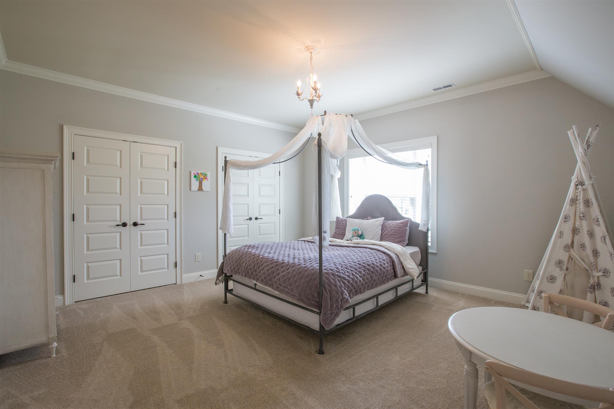 100 Truman Road West Franklin, TN 37064 - Photo 19 of 24 a spacious bedroom with a bed and a chandelier