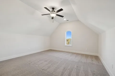 an empty room with a window and a ceiling fan