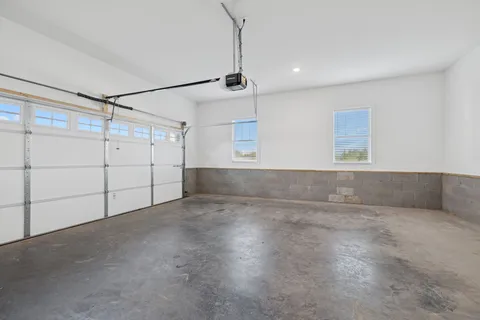 a view of an empty room and chandelier fan