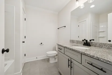 a view of a kitchen with a sink and dishwasher a refrigerator with white cabinets