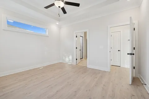 an empty room with windows and fan