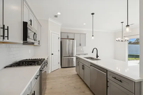 a kitchen with stainless steel appliances a refrigerator sink and stove