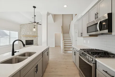 a kitchen with stainless steel appliances a refrigerator sink and microwave
