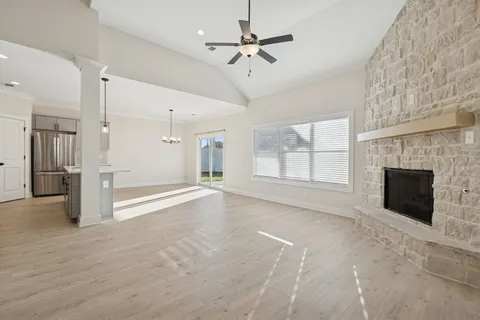 a view of an empty room with a fireplace and a window