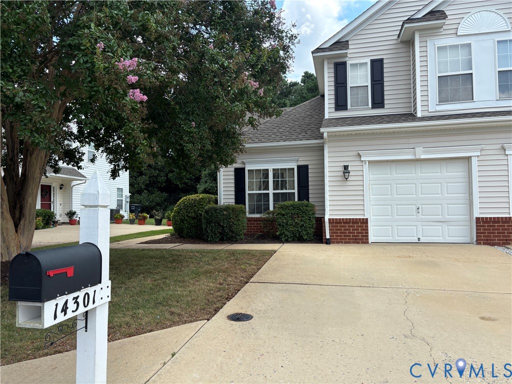 a view of a white house with a small yard and large tree