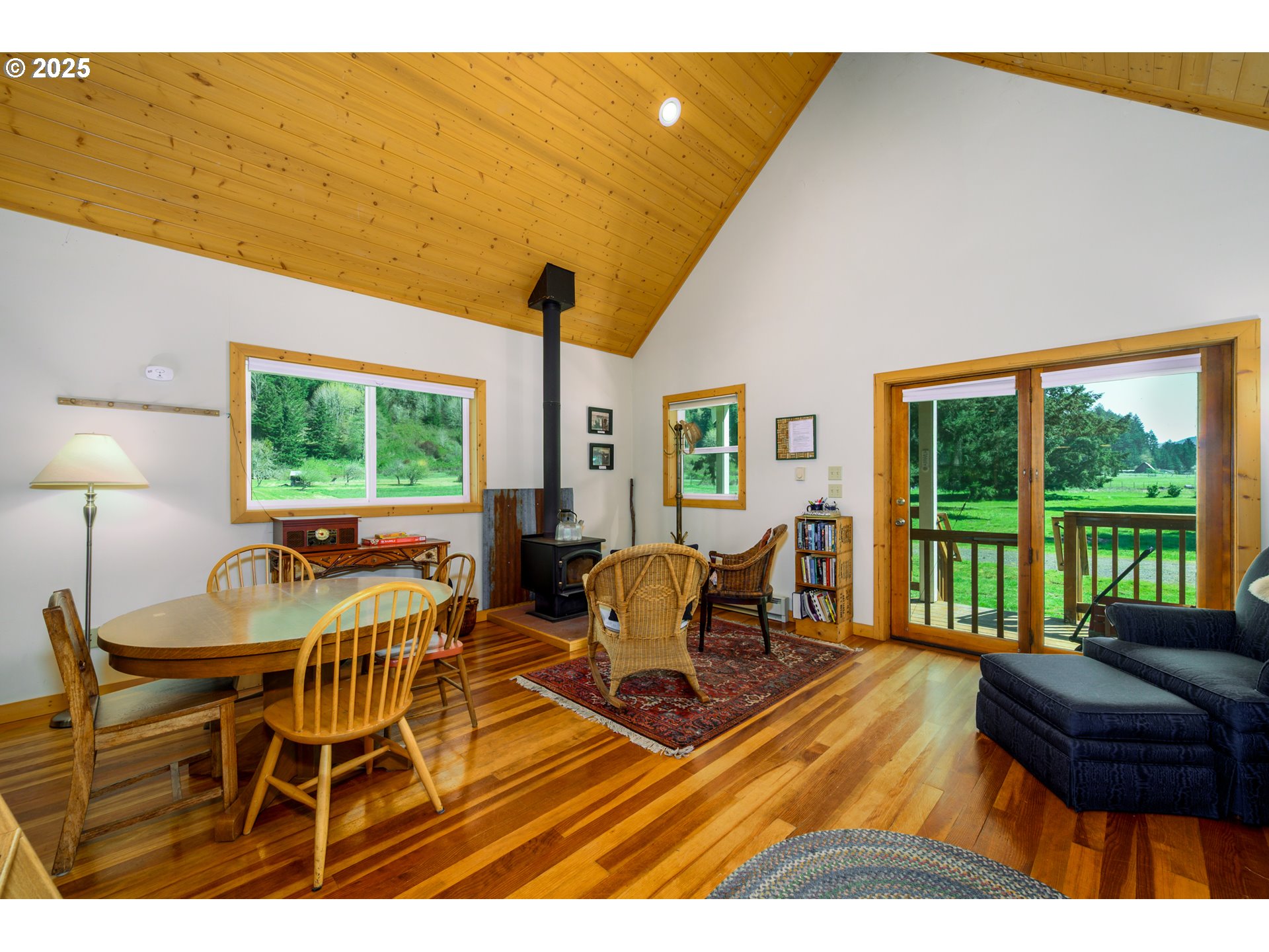 38305 Lower Brice Creek Road Dorena, OR 97434 - Photo 9 of 40 a living room with furniture a large window and a flat screen tv