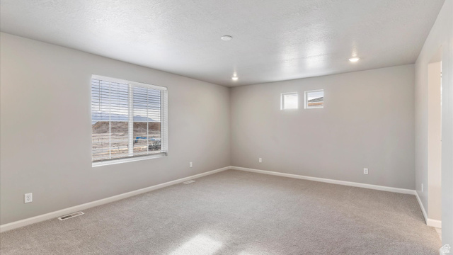 82 Provo River Road, Unit 251 Saratoga Springs, UT 84045 - Photo 19 of 32 Spacious room with neutral wall tones and light gray carpet