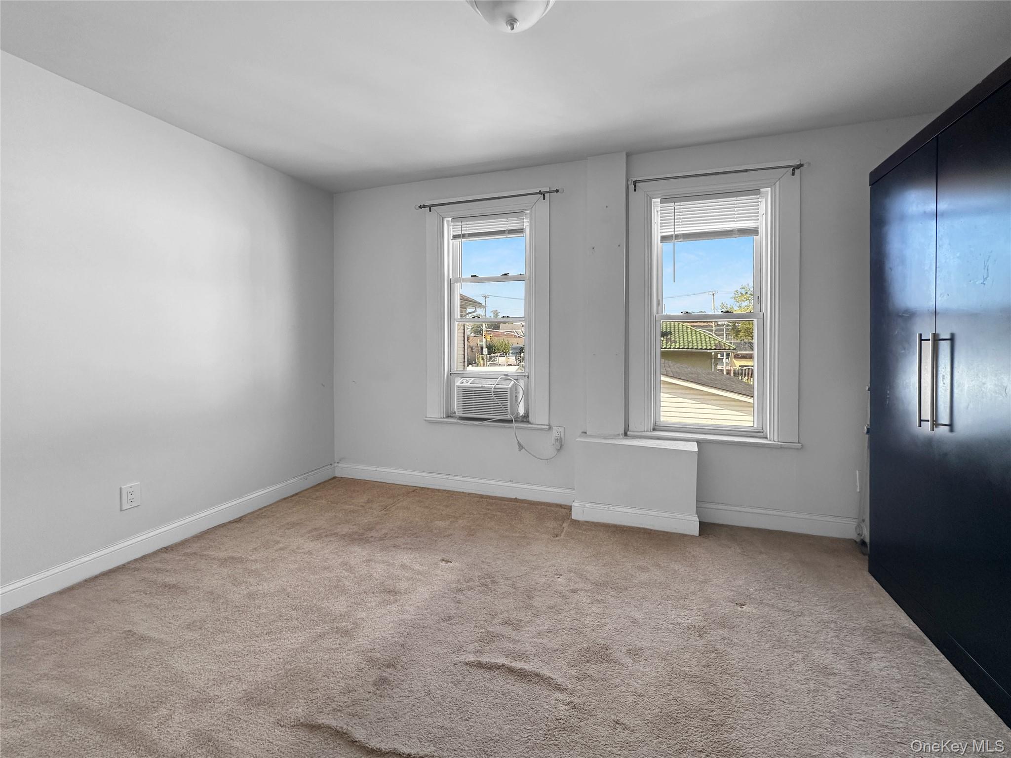 109-66 153rd Street Queens, NY 11433 - Photo 14 of 15 Empty room with light carpet and baseboards