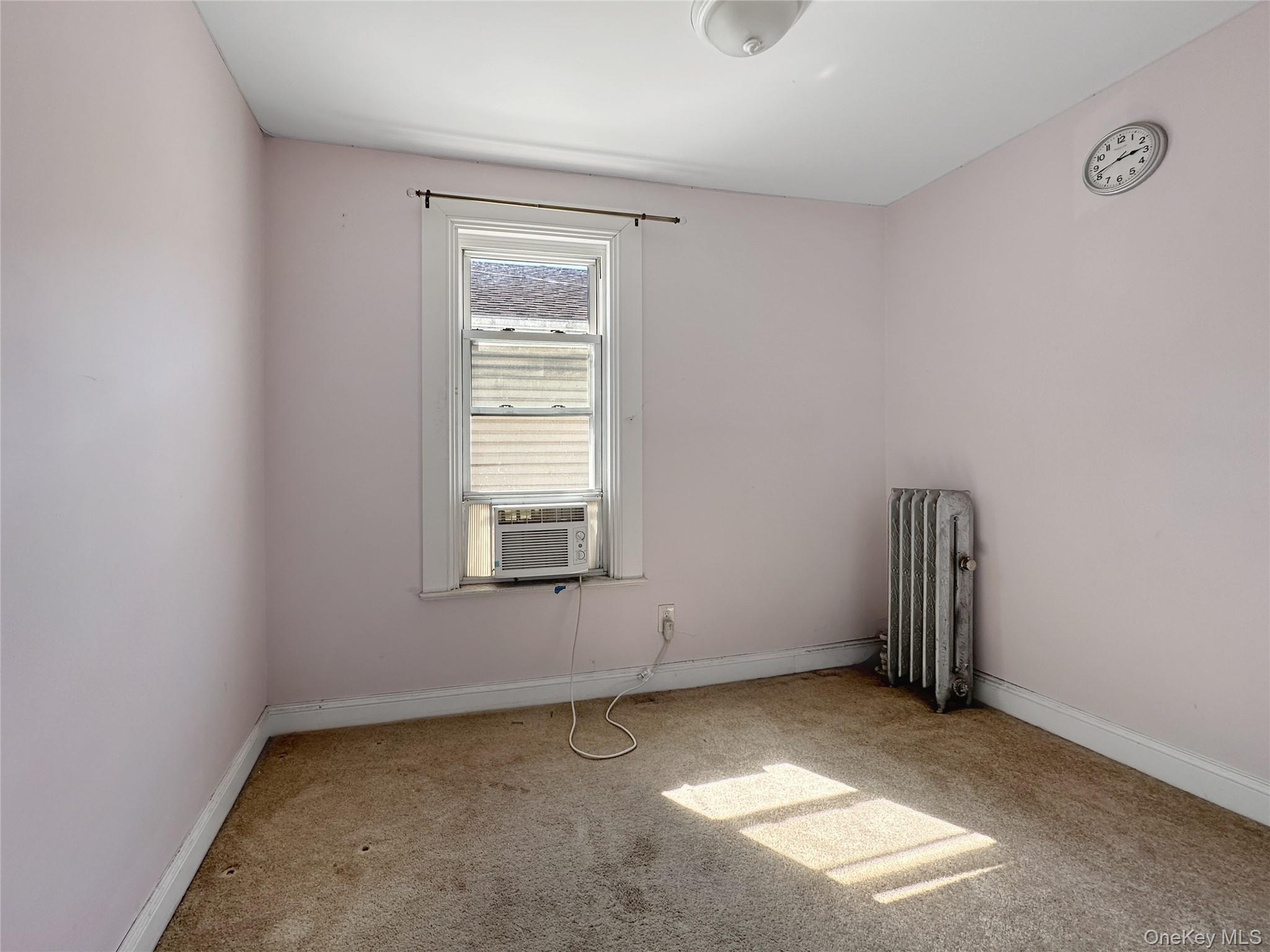 109-66 153rd Street Queens, NY 11433 - Photo 10 of 15 Spare room with radiator and carpet flooring