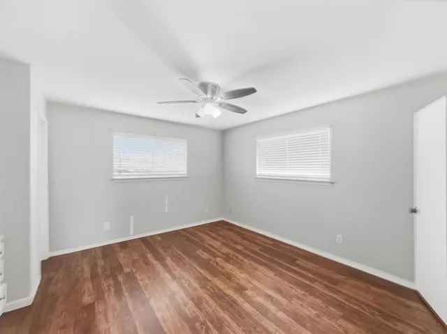 a view of a room with wooden floor and a ceiling fan
