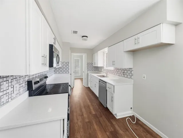 a large white kitchen with a large window