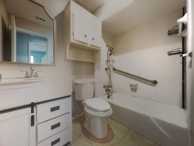 a bathroom with a sink a toilet and a mirror