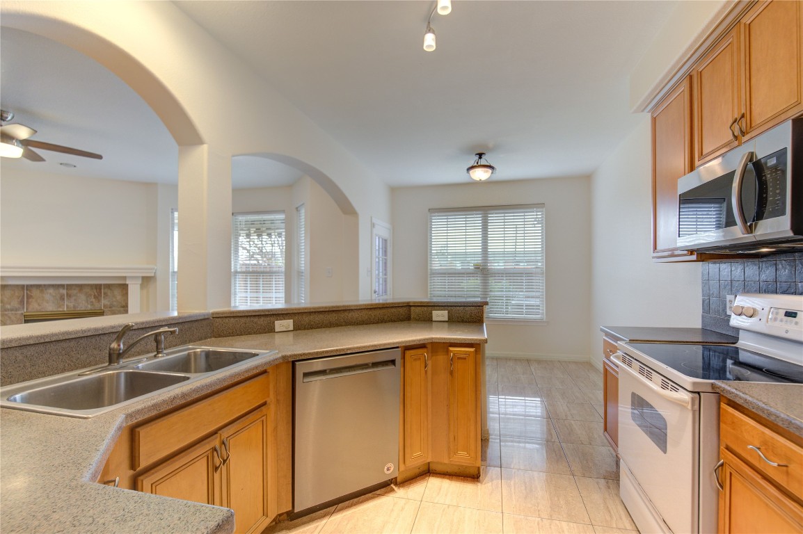 7611 South Linpar Court Houston, TX 77040 - Photo 18 of 49 a kitchen that has a sink and a stove top oven