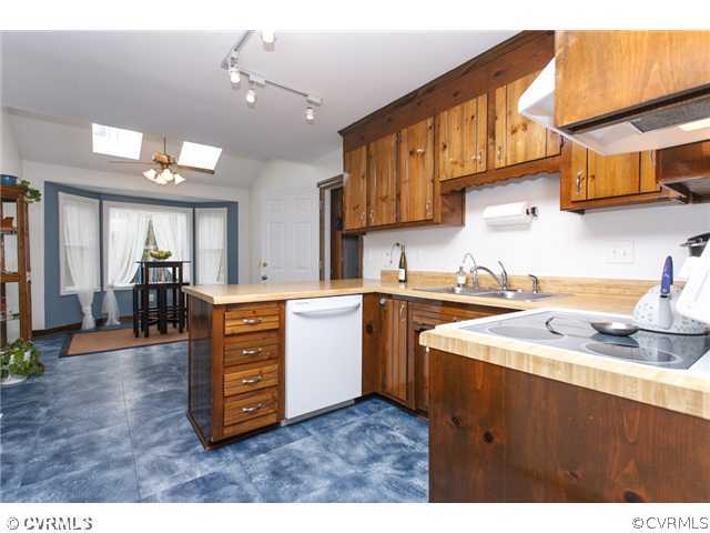 7317 Barkbridge Road Chesterfield, VA 23832 - Photo 8 of 24 a kitchen with stainless steel appliances kitchen island granite countertop a sink dishwasher a stove and a dining table with wooden floor