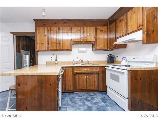 7317 Barkbridge Road Chesterfield, VA 23832 - Photo 9 of 24 a kitchen with kitchen island granite countertop a sink window and cabinets