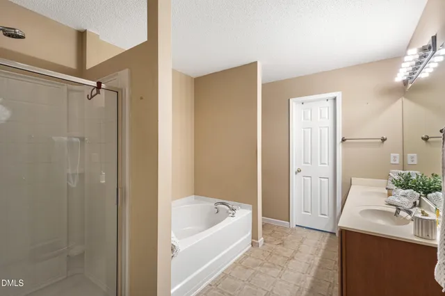 a bathroom with a tub a sink and a large mirror