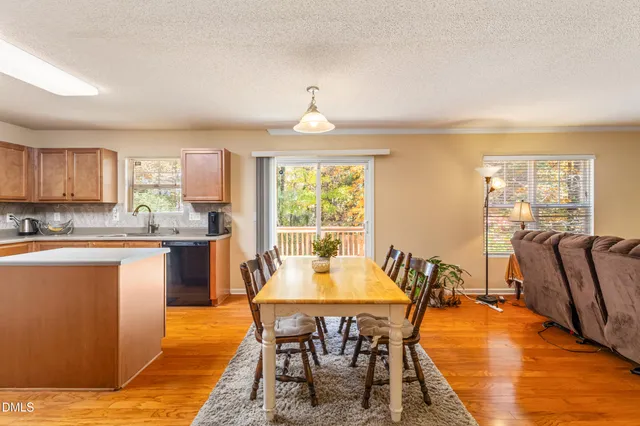 a dining room with furniture a chandelier and wooden floor
