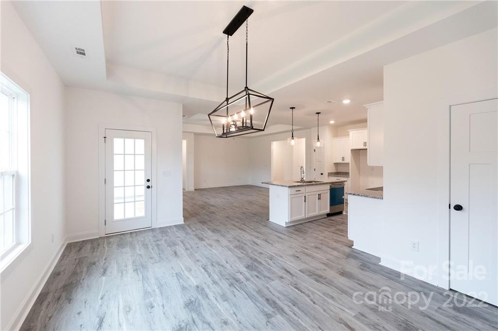2231 State Rd S-46-1474, Unit 17 Clover, SC 29710 - Photo 4 of 20 a kitchen with stainless steel appliances granite countertop a refrigerator a sink dishwasher a stove and white countertops with wooden floor