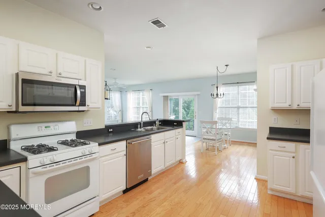 a kitchen with granite countertop a stove a sink and a microwave