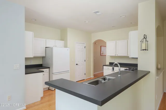 a kitchen with kitchen island a sink a stove and refrigerator