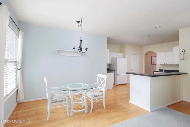 a kitchen with stainless steel appliances kitchen island granite countertop a dining table chairs and sink