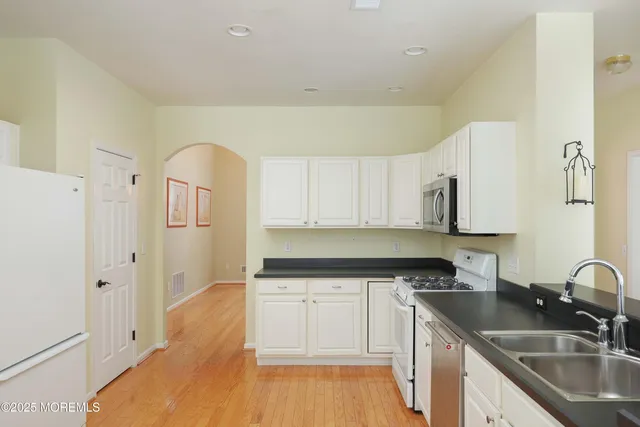 a kitchen with a sink a refrigerator and cabinets
