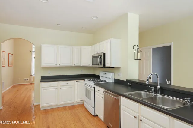 a kitchen with a sink cabinets and stainless steel appliances