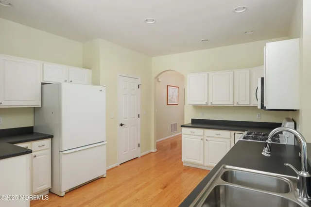 a kitchen with a refrigerator stove and white cabinets