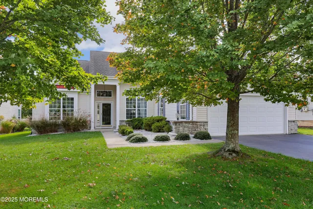 a view of a house with backyard and a tree
