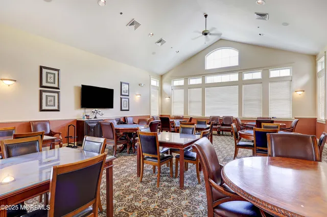 a dining room with wooden floor a chandelier a wooden table and chairs