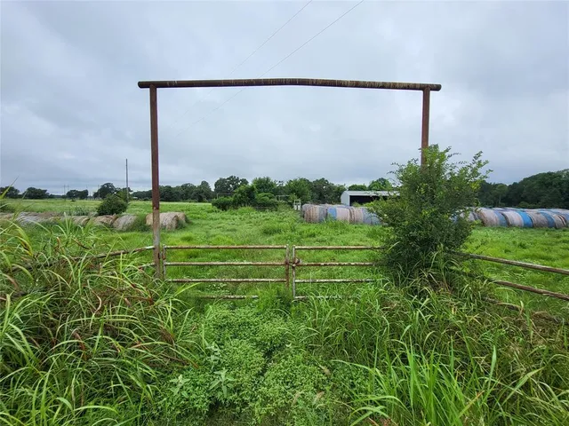 a view of a green field with wooden fence
