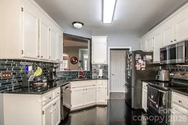 a kitchen with stainless steel appliances a refrigerator sink and cabinets