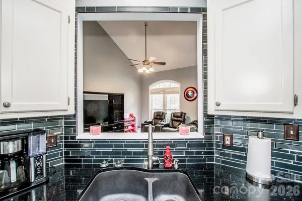 a kitchen with granite countertop a sink stainless steel appliances and cabinets