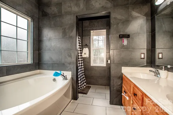 a en suite bathroom with a tub sink and shower