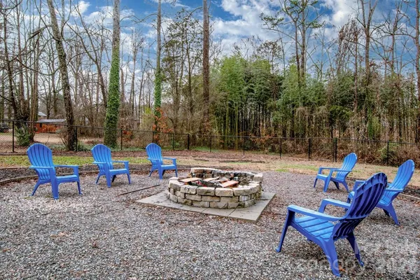 a view of a backyard with chairs and a fire pit