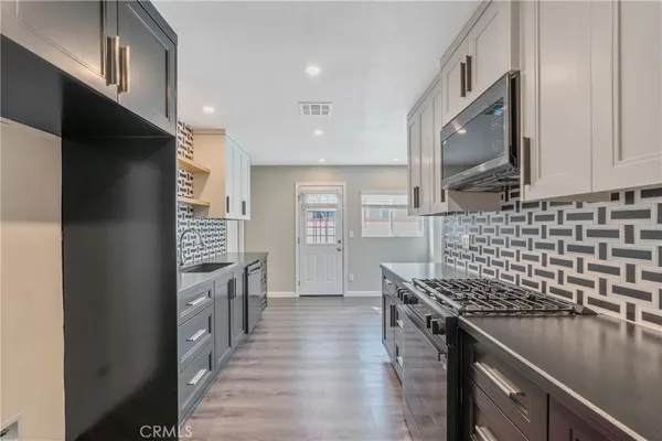 a kitchen with stainless steel appliances granite countertop a refrigerator and a stove top oven