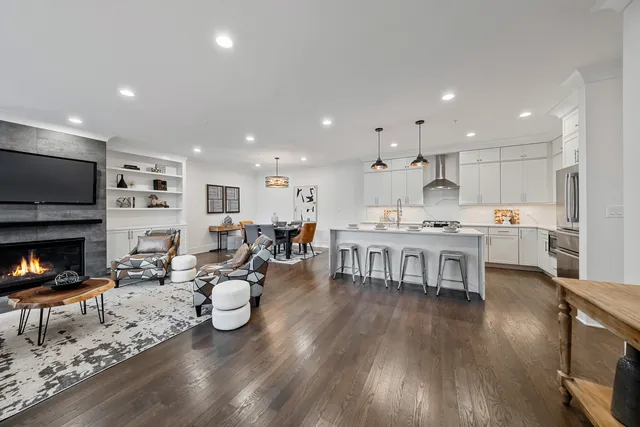 a living room with furniture and a dining table with wooden floor