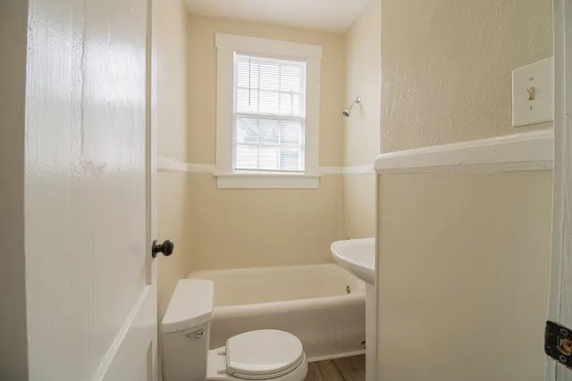 a bathroom with a toilet a sink and bathtub