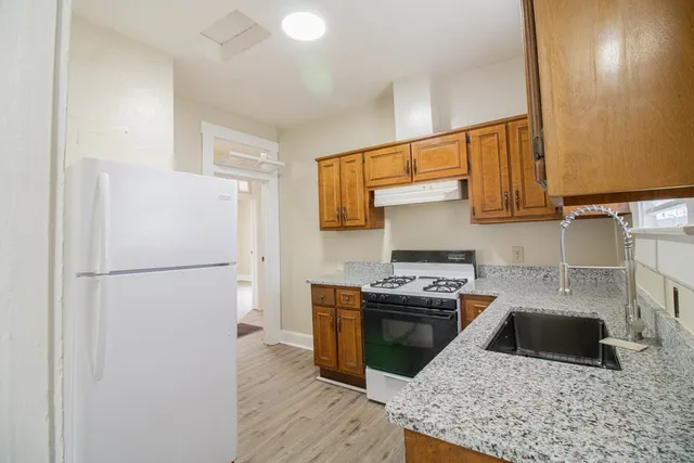 a kitchen with a stove a refrigerator and a sink