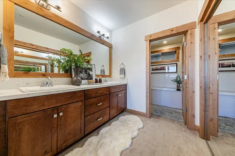 a spacious bathroom with a double vanity sink a large mirror and a shower