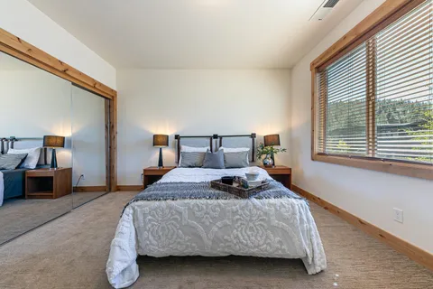 a bedroom with a bed a window and dresser