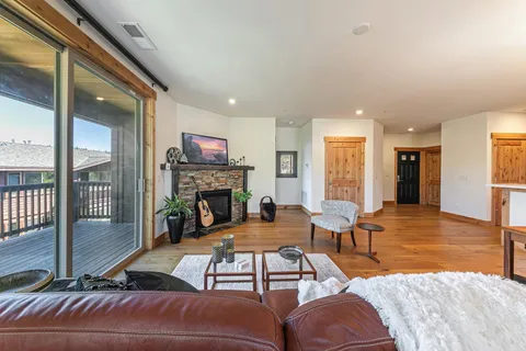 a living room with furniture a large window and glass door